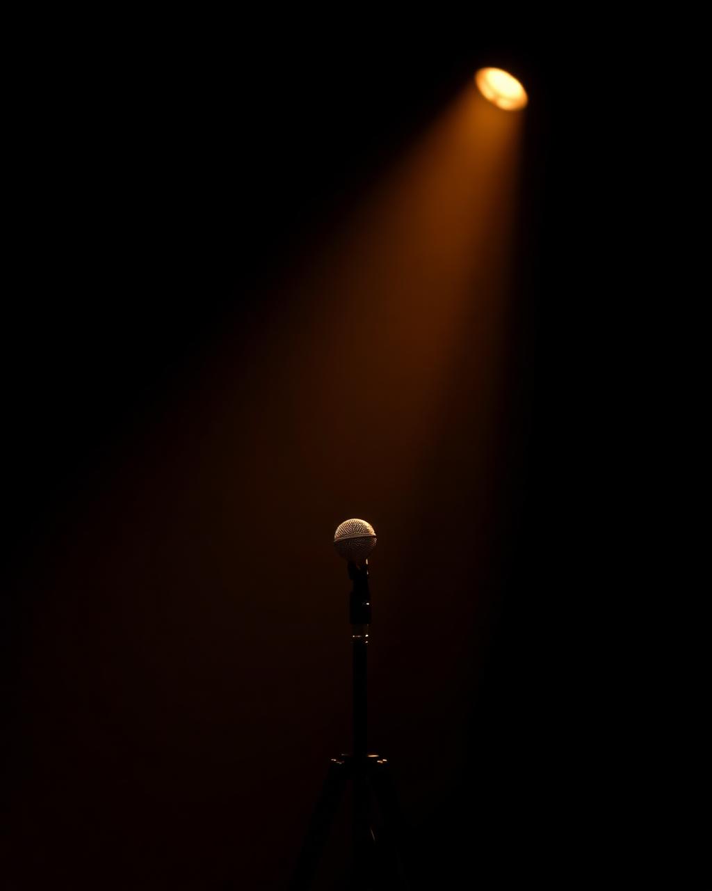 A single microphone under a spotlight.